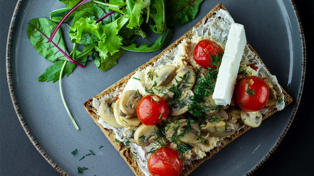 Belegtes Brot mit Champignons und Tomaten