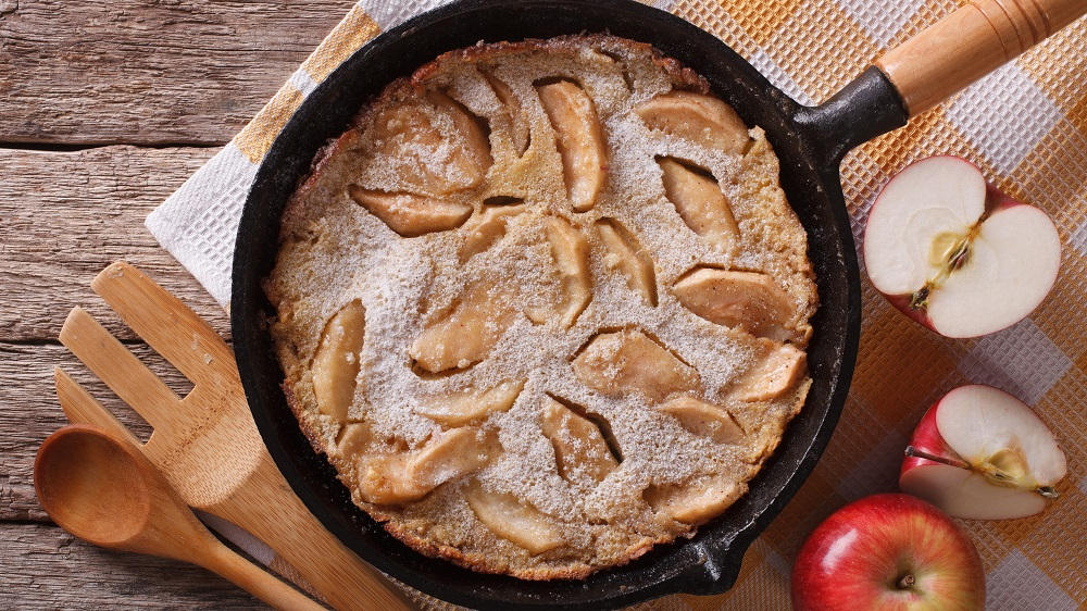 Ofenpfannkuchen mit Apfelstücken in einer Pfanne.