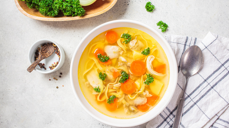 Nudelsuppe mit Gemüse und Hähnchenfleisch in einer Schüssel.