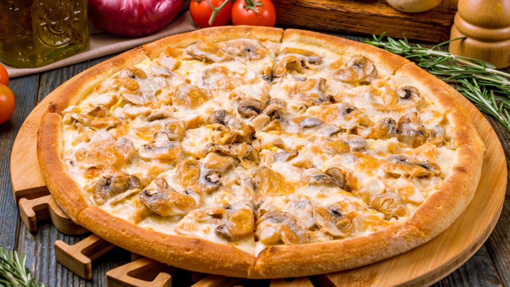 Pizza Funghi auf einem Holzbrett.