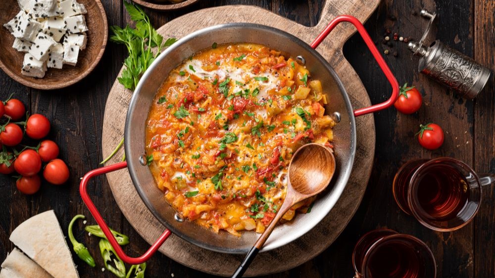 Menemen in einer Pfanne mit Löffel.